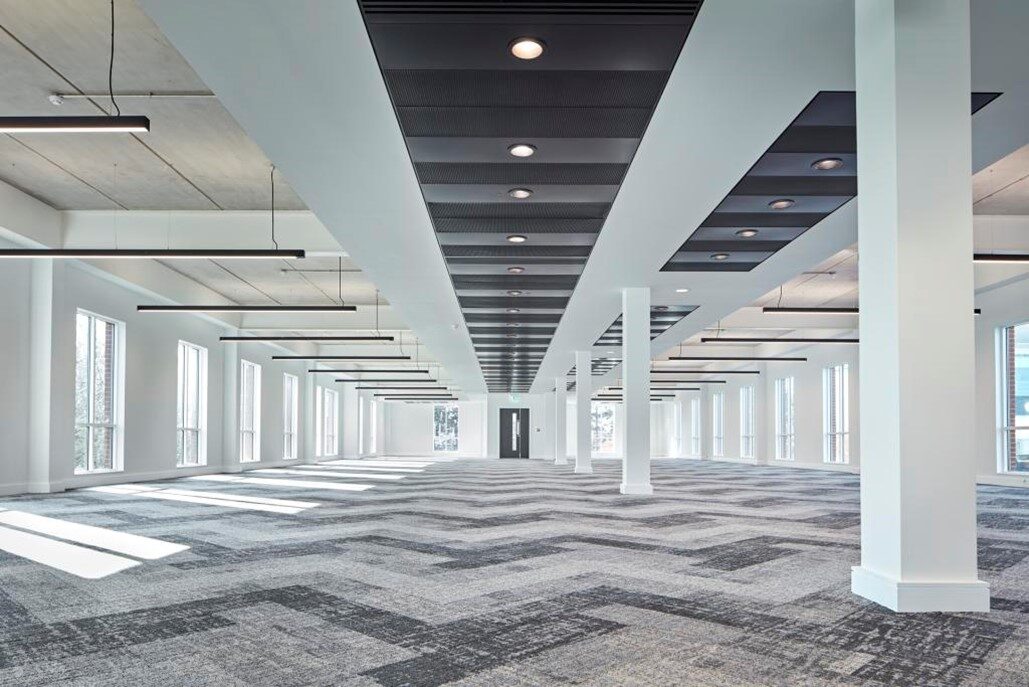 A large open-plan commercial office floor fitted out by CFE, with a modern services ceiling and recessed lighting